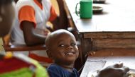 A child looks at its nanny as it takes a meal at the Saint Genevieve Welcome and Transit Centre for so-called 'cursed children', located in the northern town of Katiola, Ivory Coast, on November 4, 2016. AFP / ISSOUF SANOGO