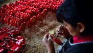 An employee makes Christmas ornaments at a factory in Tlapujahua, Michoacan State, Mexico, on December 16, 2016. Tlapujahua has several factories of Christmas ornaments, being this activity one of the most important for the economy of the town. / AFP / Ro