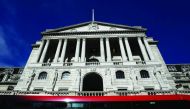 People travel on a bus as it passes the Bank of England in London.