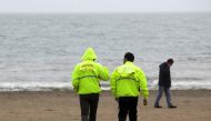 Lifeguards walk on an evacuated beach in Penco town during a tsunami alert after a quake hit Chiloe island, southern Chile, December 25, 2016. REUTERS/Juan Gonzalez