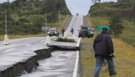 People inspect damage caused on highway 5 south on Chiloe Island off the Pacific coast of southern Chile, by a 7.7-magnitude earthquake on December 25, 2016. AFP / ALVARO VIDAL
