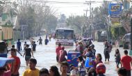 Residents wade across a flooded street brought by heavy rains and strong winds of Typhoon Nock-ten which cut through Naboa town, Camarines Sur, Bicol region, central Philippines December 27, 2016. REUTERS/Romeo Ranoco