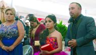 Rubi Ibarra is pictured between her parents Cresencio (right) and Anaelda during a mass for her 15th birthday celebrations in La Joya, San Luis Potosi State. 