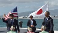 US President Barack Obama (R) looks on as Japanese Prime Minister Shinzo Abe greets veterans at Kilo Pier overlooking the USS Arizona Memorial on December 27, 2016 at Pearl Harbor in Honolulu, Hawaii. AFP / Nicholas Kamm
