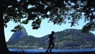 A man runs along Rio de Janeiro's promenade on December 28, 2016. The first summer days in Rio de Janeiro brought a heat wave that reached a windchill factor of 50 degrees Celsius. AFP / VANDERLEI ALMEIDA