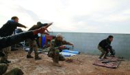 Iraqi security forces take cover during clashes with IS militants, north of Mosul, Iraq, yesterday.