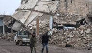 Rebel fighters walk near damaged buildings in al-Rai town, northern Aleppo countryside, Syria December 30, 2016. REUTERS/Khalil Ashawi
