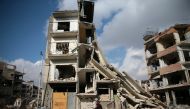 A man rides a bicycle near damaged buildings in the rebel held besieged city of Douma, in the eastern Damascus suburb of Ghouta, Syria December 30, 2016. REUTERS/Bassam Khabieh TPX IMAGES OF THE DAY.