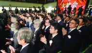 Business leaders and investors clap their hands during the closing ceremony to celebrate the last trading day of 2016 at the Tokyo Stock Exchange in Tokyo on December 30, 2016. Tokyo's benchmark stock index ended a volatile 2016 to mark the fifth annual g
