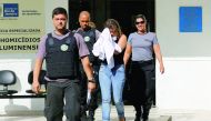 Francoise Souza Oliveira, wife of Greek Ambassador for Brazil Kyriakos Amiridis, is escorted by police as she is transferred from the police station to a jail in Brazil, yesterday.