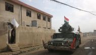 A resident waves towards Iraqi forces advancing in Mosul's eastern Al-Intisar neighbourhood on December 31, 2016, during an ongoing military operation against Islamic State (IS) group jihadists. / AFP / AHMAD AL-RUBAYE
