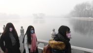 Chinese women wear masks on a heavily polluted day in Beijing on January 1, 2017. China's capital city started the year under a heavy blanket of grey smog, with a concentration of toxic particles 20 times higher than the maximal level recommended by the W