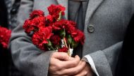 A woman holds flowers in front of the Reina night club, on January 2, 2017 in Istanbul, one day after a gunman killed 39 people, including many foreigners, in a rampage at an upmarket nightclub in Istanbul where revellers were celebrating the New Year. / 