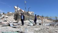 Somali policemen walk through the rubble after a suicide attack at a checkpoint outside the main base of an African Union peacekeeping force in the Somali capital Mogadishu, January 2, 2017. REUTERS/Feisal Omar
