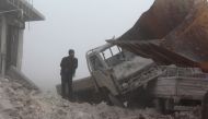 A man inspects the area after warcrafts belonging to Assad Regime forces attacked with vacuum bomb to Etarib district of Aleppo, Syria on January 1, 2017.  Ahmed al Ahmed - Anadolu Agency 

