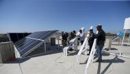 Palestinian workers install solar panels atop the roof of a medical centre in Gaza City, March 1, 2016 (REUTERS / Ibraheem Abu Mustafa) 
