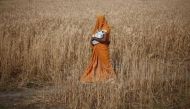 REPRESENTATIVE IMAGE: A woman carries her baby as she walks through a wheat field in Amroha district in Uttar Pradesh, April 17, 2014 (REUTERS / Adnan Abidi) 