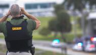 A Broward County sheriff’s deputy stands on a highway entering Fort Lauderdale International Airport, using binoculars to look towards the airport on January 06, 2017 in Florida, USA. ( Carlos Miller - Anadolu Agency )
