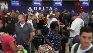 People stand in line as they wait for their flights at Terminal 2 where yesterday a shooter killed five people and wounded six others in the baggage area before he was taken into custody, at the Fort Lauderdale-Hollywood International airport on January 7