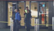 Airport security personnel stand in front of one of the entrances to the baggage area of Terminal 2, where yesterday a shooter killed five people and wounded six others before he was taken into custody, at the Fort Lauderdale-Hollywood International airpo