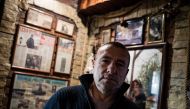 Renato Grbic, a Belgrade fisherman and restaurant owner, poses for a picture in front of newspaper articles about him and his suicide rescues, in Belgrade on December 21, 2016. Over the span of nearly two decades, Grbic, 55, has rescued 29 people who have