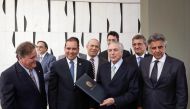 Michel Temer holds a folder with a document notifying him of becoming the interim president at his Jaburu Palace official residence in Brasilia, May 12, 2016 (Reuters) 