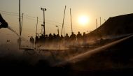 IN AN ANOTHER INCIDENT, Indian fire fighters douse a fire among the temporary tents used by the state police officials as bystanders watch on Gangasagar Island, around 150 kms south of Kolkata on January 14, 2017. More than 700,000 Hindu pilgrims and sadh