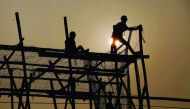 Workers build scaffolding at a construction site in Beijing.