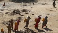 Women carry jerry cans of water from shallow wells dug from the sand along the Shabelle River bed, which is dry due to drought in Somalia's Shabelle region, March 19, 2016. REUTERS/Feisal Omar