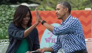 Barack Obama and Michelle Obama high five each other after reading 