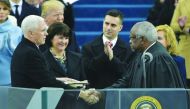 Vice-President Mike Pence shakes hands with justice Clarence Thomas as he takes the oath of allegiance during his swearing-in. His wife Karen Pence and others look on.