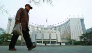 A man walks past the People's Bank of China (PBOC) headquarters in Beijing.
