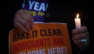 Migrant rights groups hold candles during a vigil to protest against US President Donald Trump's new crackdown on 