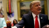 U.S. President Donald Trump holds a beverage as he attends a breakfast meeting with small business leaders hosted by Trump at the Roosevelt room of the White House in Washington U.S., January 30, 2017. REUTERS/Carlos Barria