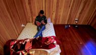 FILE PHOTO: Ali Rasooli, a refugee from Afghanistan, sits on his mattress reading a book in a house he rents with other refugees in the western Sydney suburb of Guildford Australia, July 17, 2016 (REUTERS / David Gray) 