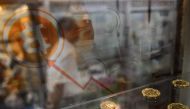 A man walking past a display cabinet containing models of Bitcoins in Hong Kong on August 3, 2016 (AFP / Anthony Wallace) 