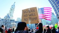 Protester Brandon McTear holds a sign and the American Flag as demonstrators gather to protest against US President Donald Trump, during a rally in Philadelphia, Pennsylvania.