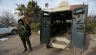 A rebel fighter stands with his weapon near a military vehicle on the outskirts of the northern Syrian town of al-Bab, Syria February 8, 2017. REUTERS/Khalil Ashawi.
