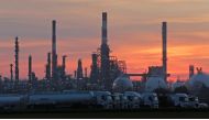 The sun sets behind the chimneys of the Total Grandpuits oil refinery and petrol depot southeast of Paris, France, February 29, 2016. (REUTERS/Christian Hartmann/File Photo)