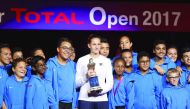 Karolina Pliskova of the Czech Republic poses for a photograph with the winner's trophy, ball boys and ball girls after defeating Denmark's Caroline Wozniacki during their WTA Qatar Total Open final at the Khalifa International Tennis Complex in Doha yest