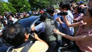 Members of the media chase a North Korean official car to ask questions at the Foreign Ministry in Putrajaya, Malaysia, February 20, 2017. REUTERS/Athit Perawongmetha
