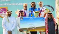 Danka Bartekova (centre) of Slovakia, winner of the skeet title at the Qatar Total Open, celebrates on the podium at the Losail Shooting Range, after receiving the winner's cheque from Qatar Shooting and Archery Association (QSAA) General Secretary Ahmed 