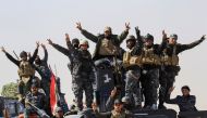 Members of the federal police react as they arrive in Albu Saif, which was recently retaken by Iraqi military forces, south of Mosul, Iraq February 22, 2017. REUTERS/Zohra Bensemra
