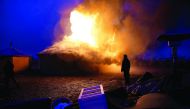 A man watches a building burn after it was set alight by protesters preparing to evacuate the main opposition camp against the Dakota Access oil pipeline near Cannon Ball, North Dakota, US, yesterday.