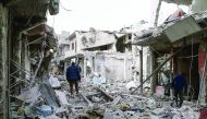 Syrian civil defence volunteers, known as the White Helmets, search for survivors following a government air strike on the rebel-held neighbourhood of Tishrin, on the northeastern outskirts of Damascus, yesterday.