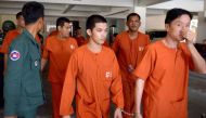 Ven Sopheap (centre) is escorted by a prison guard at the Phnom Penh Municipal Court, yesterday. 
