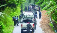 Police investigate the scene of a shooting in Khoksator village in southern Thailand, yesterday.