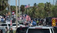 The motorcade of US President Donald Trump stops near supporters standing close to his Mar-a-Lago resort in Palm Beach, Florida, on March 4, 2017. AFP / NICHOLAS KAMM 