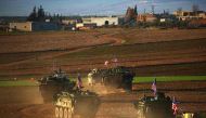 (FILES) This file photo taken on March 5, 2017 shows a convoy of US forces armoured vehicles driving near the village of Yalanli, on the western outskirts of the northern Syrian city of Manbij.  AFP / DELIL SOULEIMAN
