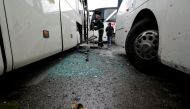 A worker clears shattered glass at the site of an attack by two suicide bombers in Damascus, Syria March 11, 2017. REUTERS/Omar Sanadiki.